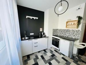 una cucina con armadietti bianchi e una parete nera di Luff Gdynia Legionow a Gdynia