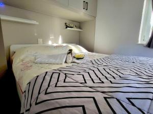 - une chambre avec un lit et une couverture noire et blanche dans l'établissement Paradiso del sole 1, à Brusino Arsizio