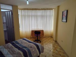 ein Schlafzimmer mit einem Bett, einem Stuhl und einem Fenster in der Unterkunft Habitación Confortable frente al Hospital Regional Ramiro Priale in Huancayo
