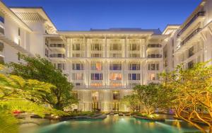 een groot gebouw met een zwembad ervoor bij Hua Chang Heritage Hotel in Bangkok