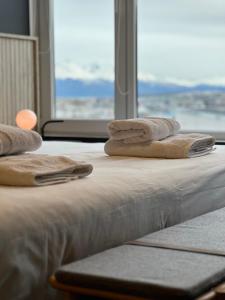two beds with towels on top of them with a window at Seaport Apartments STUDIO Austral 402 in Ushuaia