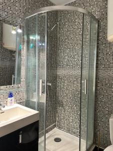 La salle de bains est pourvue d'une douche en verre et d'un lavabo. dans l'établissement Charmant Studio en rez de jardin dans propriété privé pour 4 personnes, à La Londe-les-Maures