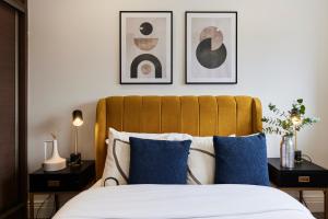 een slaapkamer met een bed met drie foto's aan de muur bij The Harlesden Escape - Spacious 3BDR Flat with Balcony in Londen