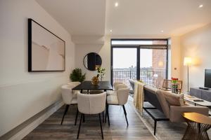 sala de estar con mesa y sillas en The Harlesden Escape - Spacious 3BDR Flat with Balcony en Londres