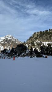 een met sneeuw bedekte berg in de verte met een skipiste bij Studio la Mongie Tourmalet 2 étoiles in Bagnères-de-Bigorre