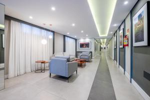 a corridor of a hospital with chairs and tables at Loft em Frente da Redenção 610 in Porto Alegre