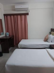 ein Hotelzimmer mit 2 Betten und einem Schreibtisch in der Unterkunft Eden 2 bhk Service Apartments in Bangalore