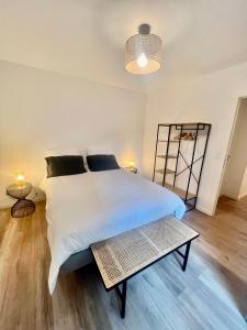 a bedroom with a large white bed and a table at La Résidence Alpha Viroflay 101 - 1 chambre - 4 pers in Viroflay