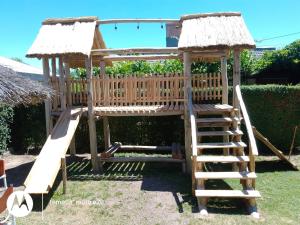 a wooden playground with a ladder and a swing at Shalom in Mina Clavero