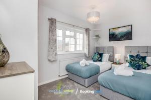 a bedroom with two beds and a couch at Ascot, Pet Friendly, Detached 4 Bedroom House By Sentinel Living Short Lets & Serviced Accommodation Windsor Ascot Maidenhead With Free Parking in Ascot