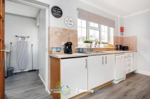 a kitchen with white cabinets and a sink at Ascot, Pet Friendly, Detached 4 Bedroom House By Sentinel Living Short Lets & Serviced Accommodation Windsor Ascot Maidenhead With Free Parking in Ascot