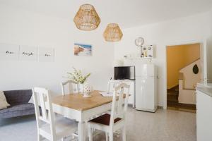 Il comprend une cuisine équipée d'une table et d'un réfrigérateur blanc. dans l'établissement Biancaleuca Rooms & Suite, à Leuca