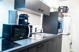 una cucina con lavandino e forno a microonde di #611 Stilvolle und komfortable Wohnung in Essen a Essen