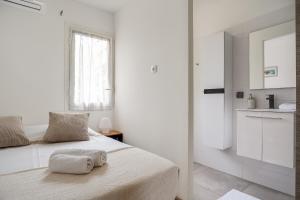 een witte slaapkamer met een bed met twee handdoeken erop bij T1 BIS Centre Ville - Vue mer ! in Saint-Pierre