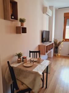 a dining room with a table and chairs and a television at Andrea A blok in Novi Beograd