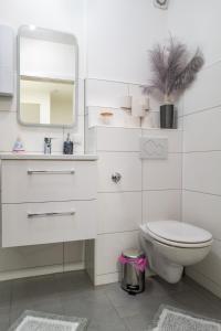 Baño blanco con aseo y espejo en #611 Stilvolle und komfortable Wohnung in Essen en Essen