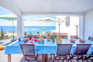 a blue table with chairs on a patio with the ocean at Villa de la Plage in Albufeira