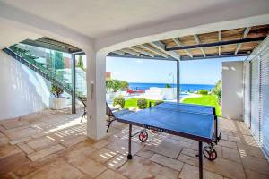 a pool table on a patio with a view of the ocean at Villa de la Plage in Albufeira