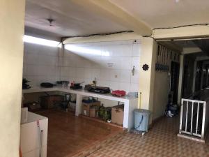 una camera con cucina con bancone e una camera con di SPOT ON 93685 Homestay Bu Sun Syariah a Sidoarjo