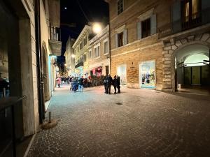 een groep mensen die 's nachts over straat lopen bij Particular apartment in San Benedetto del Tronto in San Benedetto del Tronto