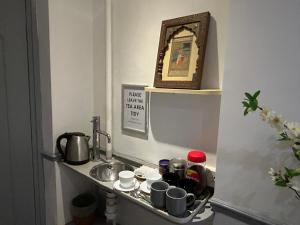 a small kitchen with a sink and a shelf at Earls Court Hotel in London