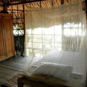 Un pat sau paturi într-o cameră la Pajarito Eco-Lodge frente al mar