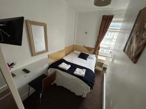 ロンドンにあるアールズ コート ホテルの小さなベッドルーム(ベッド1台、シンク付)