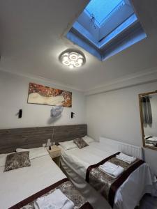 a bedroom with two beds and a skylight at Earls Court Hotel in London