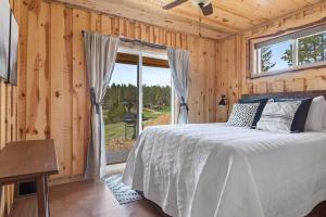 a bedroom with a bed and a large window at Sun Filled Joy BHBungalows #8 in Custer +30 photos