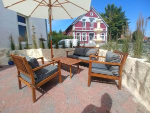 a patio with two chairs and a table and an umbrella at Nordseeperle in Norden