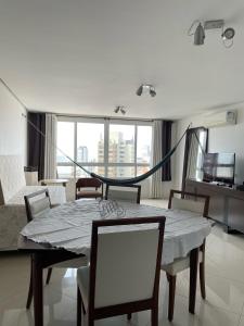 un comedor con mesa y sillas en una habitación en Apartamento com Vista Oceânica, en Torres