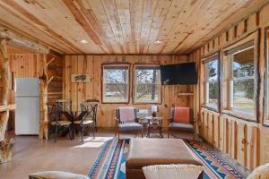 a living room with wooden walls and a table and a refrigerator at Sun Filled Joy BHBungalows #8 in Custer