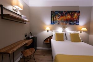 een hotelkamer met een bed en een bureau bij Grand Hôtel Du Tonneau D'Or in Belfort