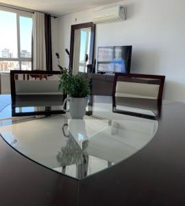 una mesa de cristal con una maceta encima en Apartamento com Vista Oceânica, en Torres