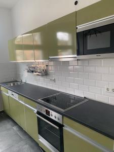 uma cozinha com um fogão, um lavatório e um micro-ondas em sima Apartment em Essen