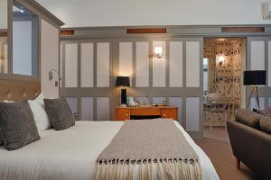 een slaapkamer met een groot bed en een bank bij Rose and Crown Stoke Newington in Londen