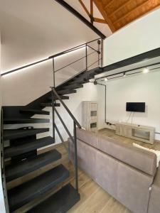 a metal staircase in a room with a tv at Emerald Apartment in Valmontone