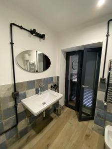 uma casa de banho com um lavatório e um espelho em Emerald Apartment em Valmontone