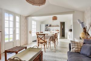 a kitchen and living room with a table and chairs at Maison pour 6 au coeur de Bretignolles-sur-Mer in Brétignolles-sur-Mer +9 photos