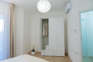 a bedroom with a white closet with a mirror at Estia Suites in Villasimius