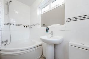 a white bathroom with a sink and a toilet at Stratford Double Rooms - 29 in London