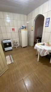 a small kitchen with a table and a refrigerator at Casa para temporada in Prado