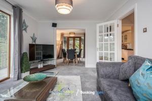 een woonkamer met een bank en een tv bij 4 Bedroom House By Sentinel Living Short Lets & Serviced Accommodation Windsor Ascot Maidenhead With Free Parking & Pet Friendly in Maidenhead