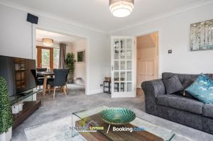 een woonkamer met een bank en een tafel bij 4 Bedroom House By Sentinel Living Short Lets & Serviced Accommodation Windsor Ascot Maidenhead With Free Parking & Pet Friendly in Maidenhead