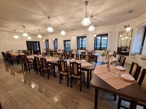 uma grande sala de jantar com mesas, cadeiras e luzes em Chata Centrum Pastvinská přehrada em Nekoř