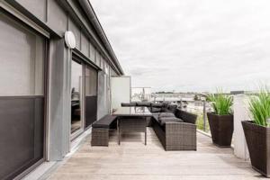 - un balcon avec un canapé et une table dans un bâtiment dans l'établissement Luminous Penthouse with Open Sky Terrace, à Sandweiler