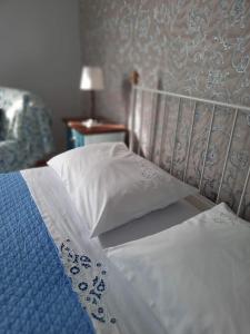 Una cama con sábanas blancas y almohadas en un dormitorio en Apartment Bella Rosa, en Koper