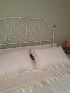 a white bed with white pillows and a metal headboard at Apartment Bella Rosa in Koper