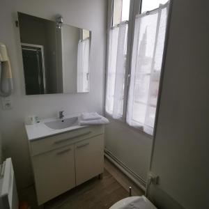 a bathroom with a sink and a mirror at Logis Hôtel & Restaurant Le Saint Savinien in Saint-Savinien