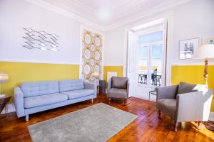 uma sala de estar com um sofá azul e duas cadeiras em Alegria by Central Hill Apartments em Lisboa